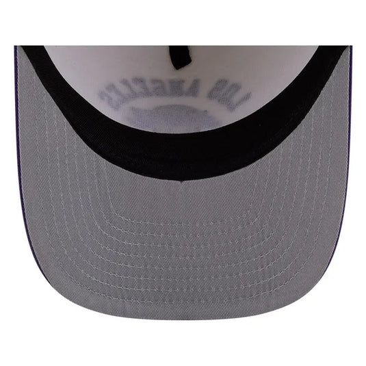 Close-up of the curved brim of a baseball cap, showing a gray fabric front with a black embroidered band and a white inner crown with gray text.