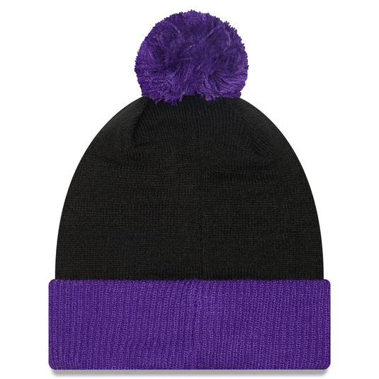A black knit beanie hat with a fluffy purple pom-pom on top and a matching purple ribbed cuff, shown against a plain white background.