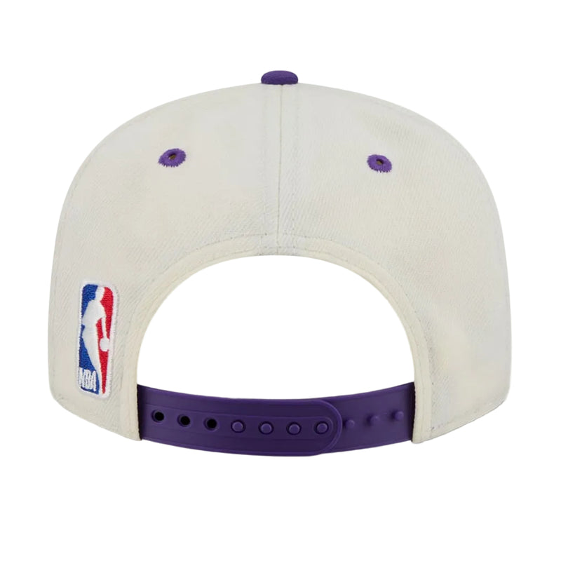 Load image into Gallery viewer, Back view of a chalk white Lakers snapback with purple buttone and eyelets and the NBA logo next to the purple snapback closure
