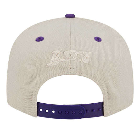 Back view of a Los Angeles Lakers baseball cap in off-white with purple accents on the button, eyelets, and adjustable strap.