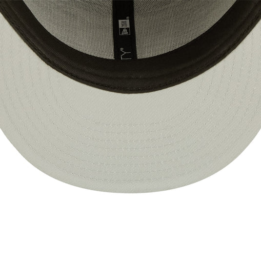 Close-up of a beige cap with a black rim on a white background