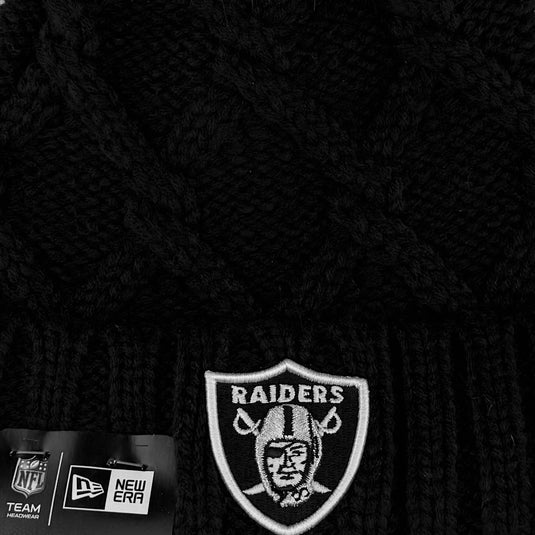 Closeup of the black knit beanie with Raiders logo on the cuff.  The embroidered logo is white with a silver helmet. 