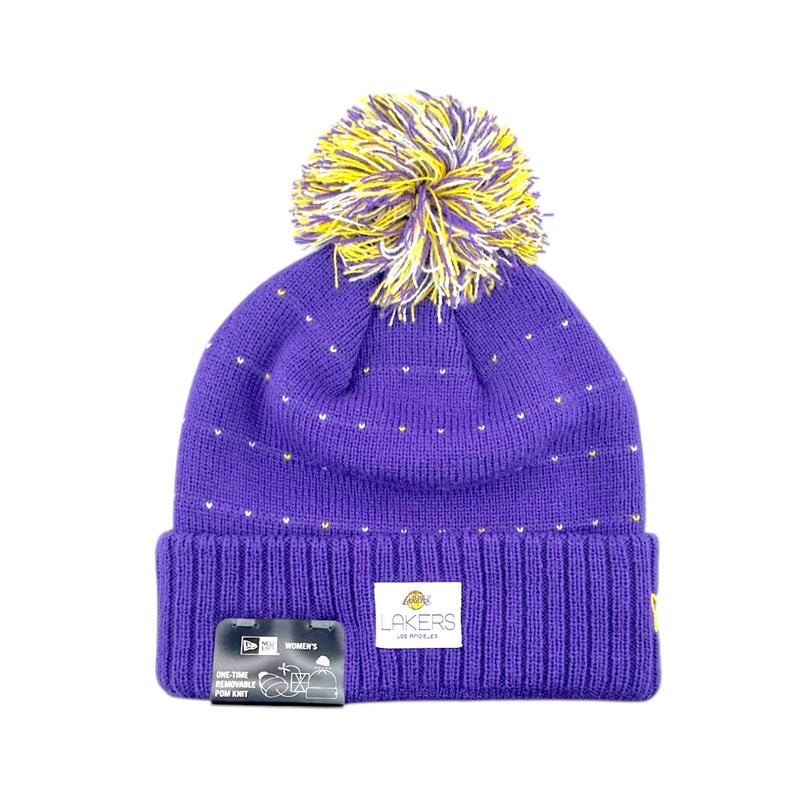 Load image into Gallery viewer, A purple knit beanie hat with a yellow and purple pom-pom, small gold star details, and a white Los Angeles Lakers patch on the front cuff. A black hangtag is attached to the left side of the cuff, and the hat is photographed against a plain white background.

