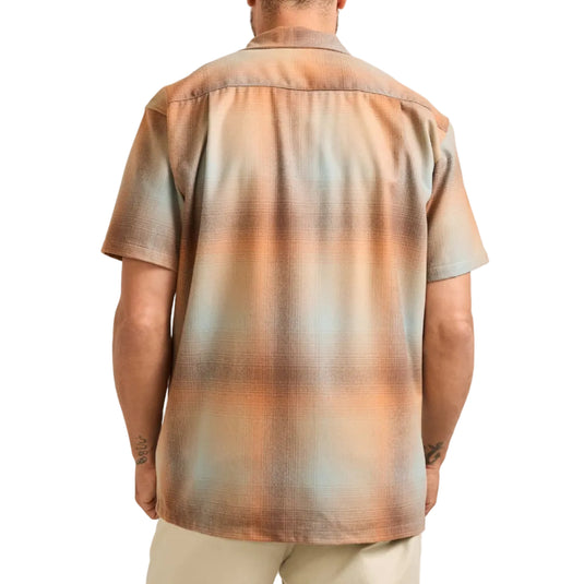 Man wearing a patterned shirt with a neutral background