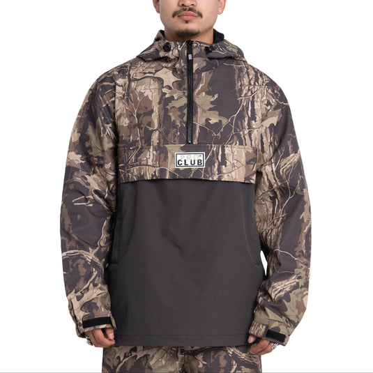 Person wearing a camouflage jacket with a visible brand logo on a white background