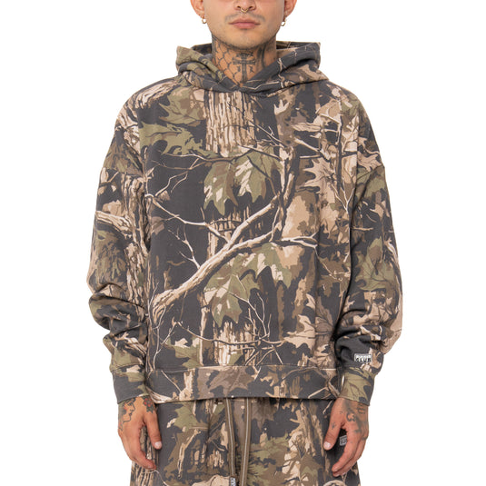 Person wearing a camouflage hoodie on a white background