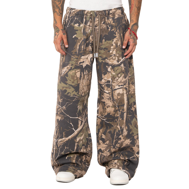 Load image into Gallery viewer, Camouflage pants worn by a person on a white background
