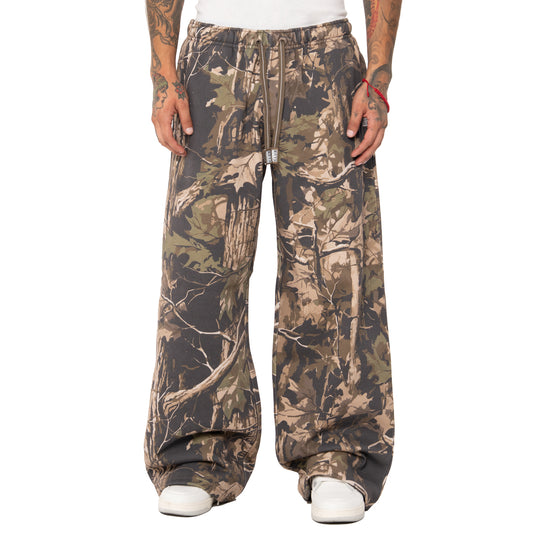 Camouflage pants worn by a person on a white background