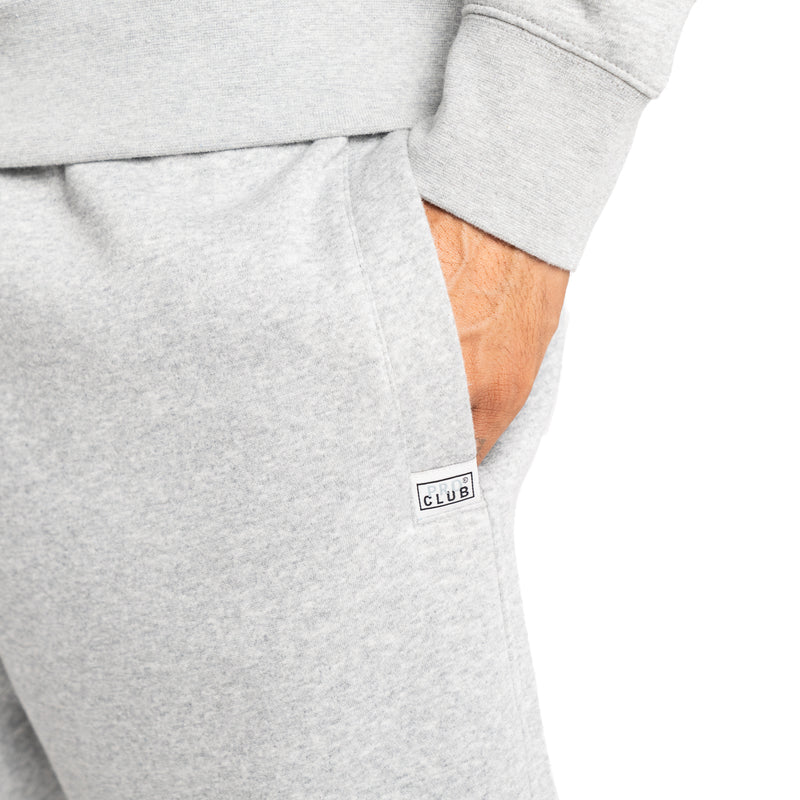 Load image into Gallery viewer, Close up shot of heather gray sweat shorts with the Pro Club logo stiched into the front of the left pocket

