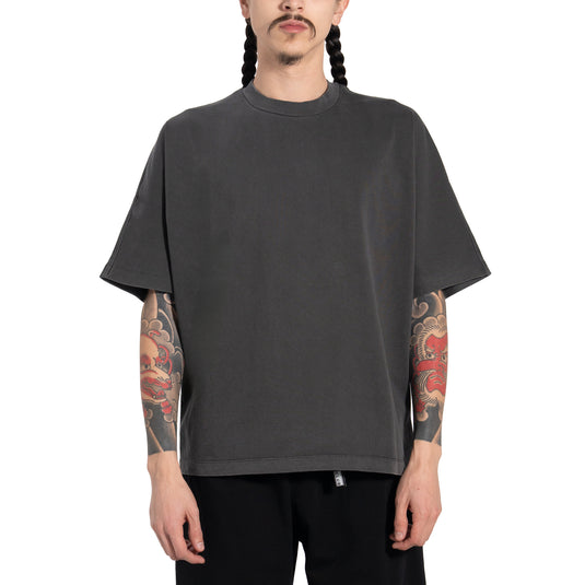 Person wearing a washed black pigment dyed t-shirt on a white background