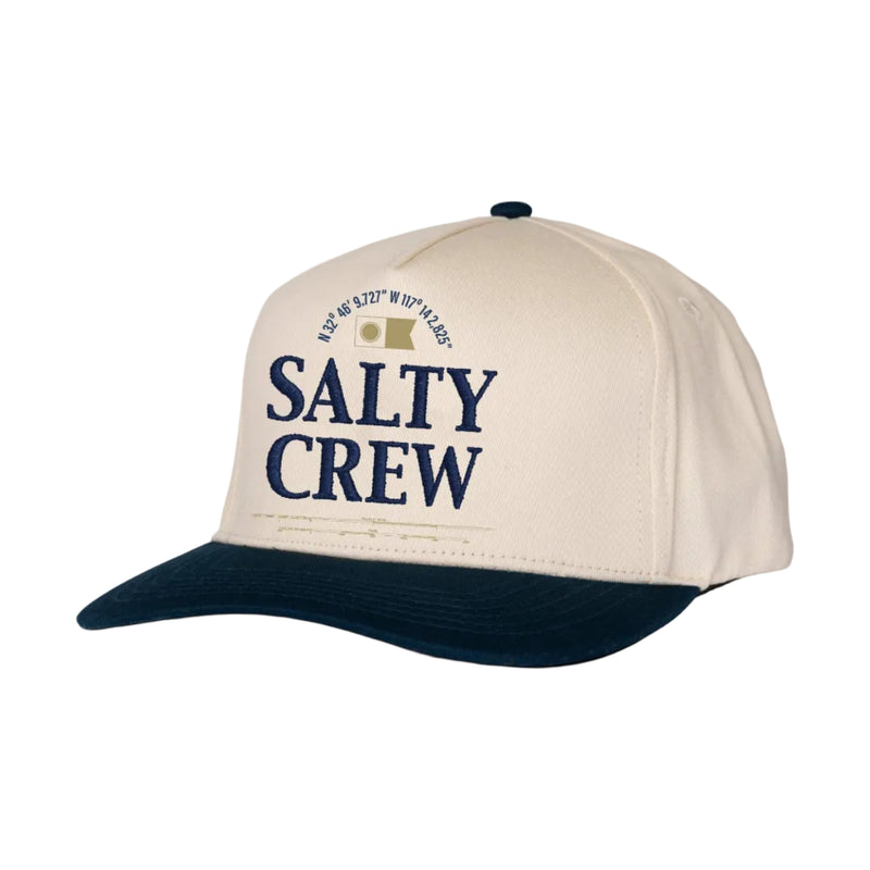 Load image into Gallery viewer, A structured baseball cap with an off-white crown and a dark navy blue curved brim. The front of the cap features the text 'SALTY CREW' in navy blue, along with a small graphic and circular text reading 'EST.
