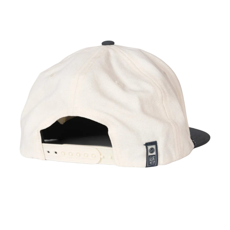 Load image into Gallery viewer, Back view of a baseball cap in off-white canvas with a black snapback closure and a small black brand patch on the side, set against a light gray background.
