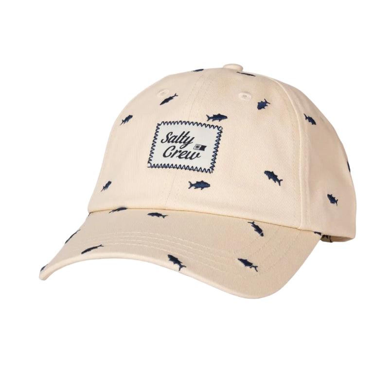 Load image into Gallery viewer, A beige baseball cap with a small navy blue fish pattern all over it and a central embroidered patch reading 'Salty Crew'.
