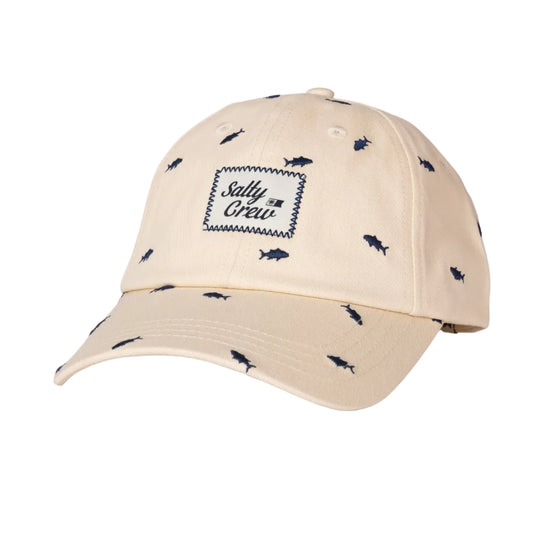 A beige baseball cap with a small navy blue fish pattern all over it and a central embroidered patch reading 'Salty Crew'.