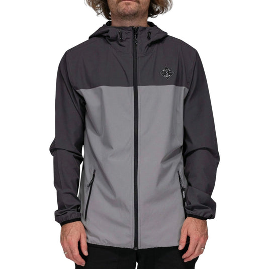 Person wearing a gray and black jacket with a brand logo on a white background