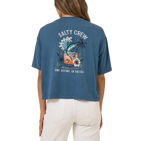 Person wearing a blue 'Salty Crew' t-shirt with a graphic design on the back against a beige background