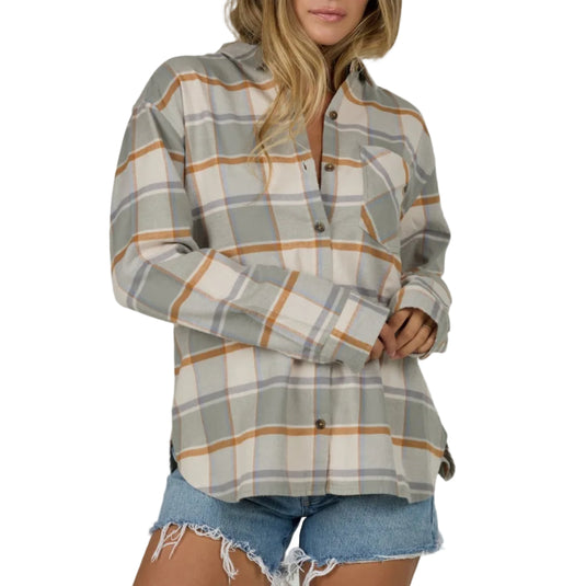 Woman wearing a gray plaid shirt and denim shorts on a plain background
