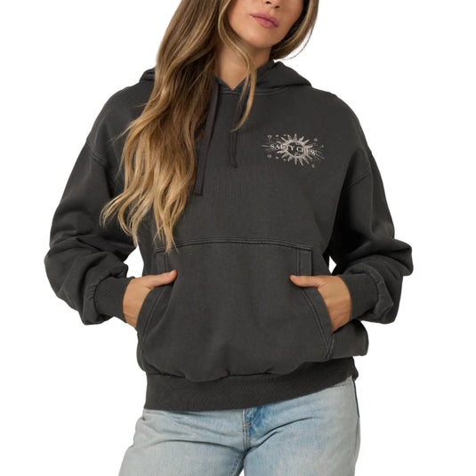 A woman modeling a dark gray half-zip hoodie with a small embroidered logo on the left chest, paired with light blue jeans, against a plain light gray background.