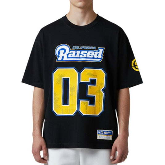 Person wearing a black t-shirt with yellow and blue text and numbers on a white background