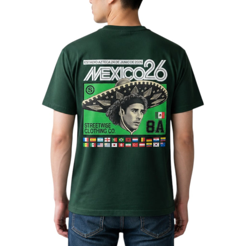 Load image into Gallery viewer, A man wearing a dark green t-shirt, viewed from the back. The shirt features a large graphic print with 'MEXICO26' in white, a green background, a large sombrero, a stylized portrait, and a row of small national flags at the bottom.
