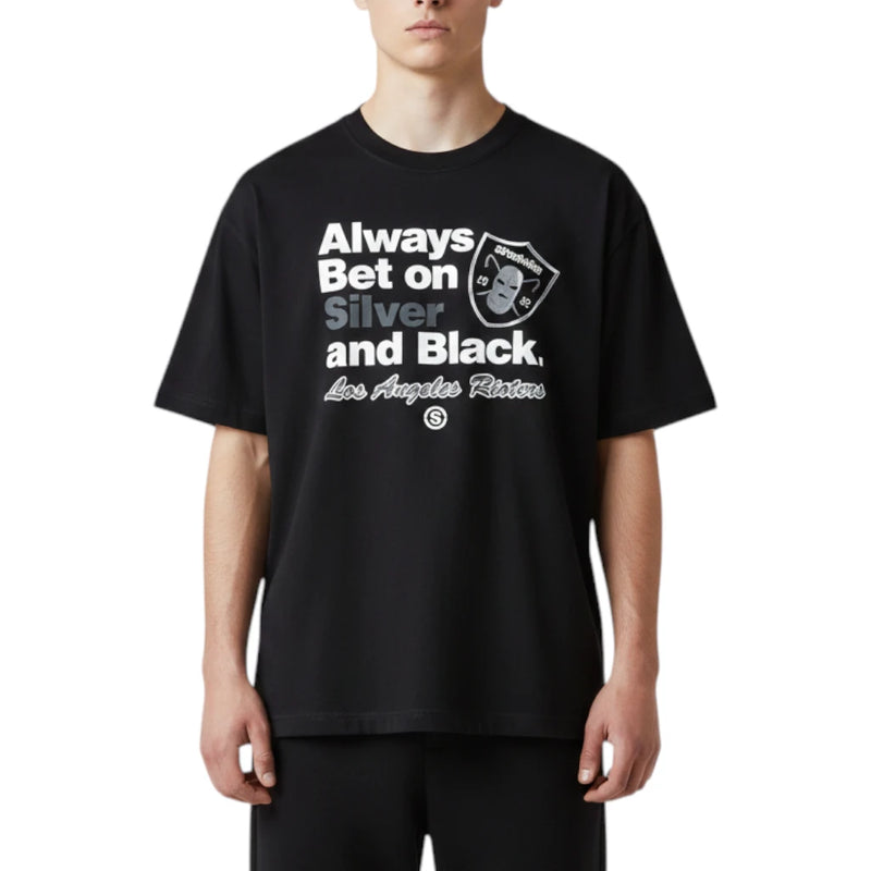 Load image into Gallery viewer, A model wearing a black oversized t-shirt with a white and silver graphic print that reads 'Always Bet on Silver and Black, Los Angeles Rioters' alongside the team logo.
