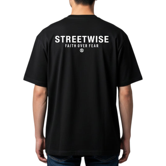 Black t-shirt with 'Streetwise Faith Over Fear' text on the back, worn by a person.