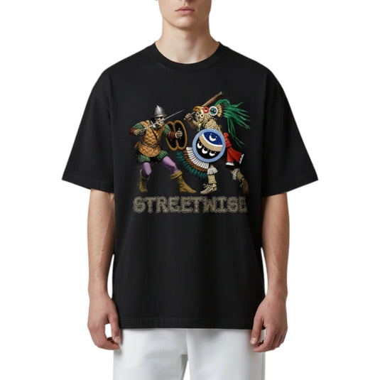 A model wearing a black oversized t-shirt with a colorful graphic of two street performers and the word 'STREETWISE' printed below it, paired with white pants against a plain white background.
