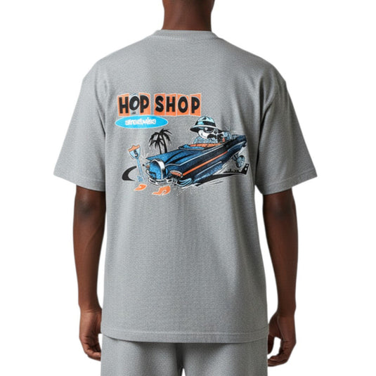 Gray t-shirt with a graphic design on the back featuring a car and text, worn by a person.