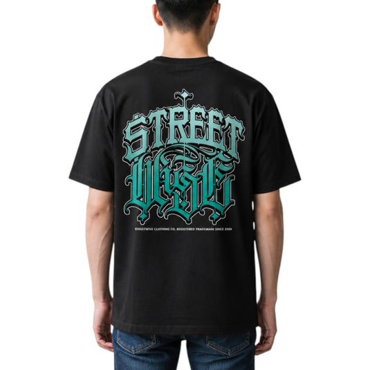 A man viewed from the back wearing a black t-shirt with a large teal and white gothic-style graphic reading 'Street Wise' on the back, paired with blue jeans against a plain white background.