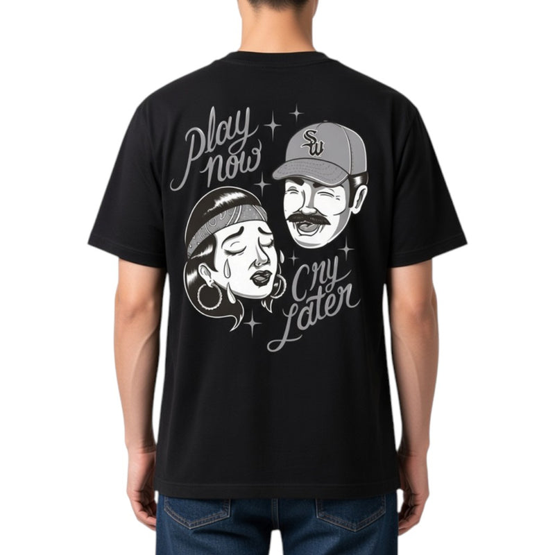 Load image into Gallery viewer, A man wearing a black short-sleeve t-shirt, viewed from the back. The shirt features a large white graphic print of a man laughing and a woman crying, with the text 'Play now cry later' and small star accents.
