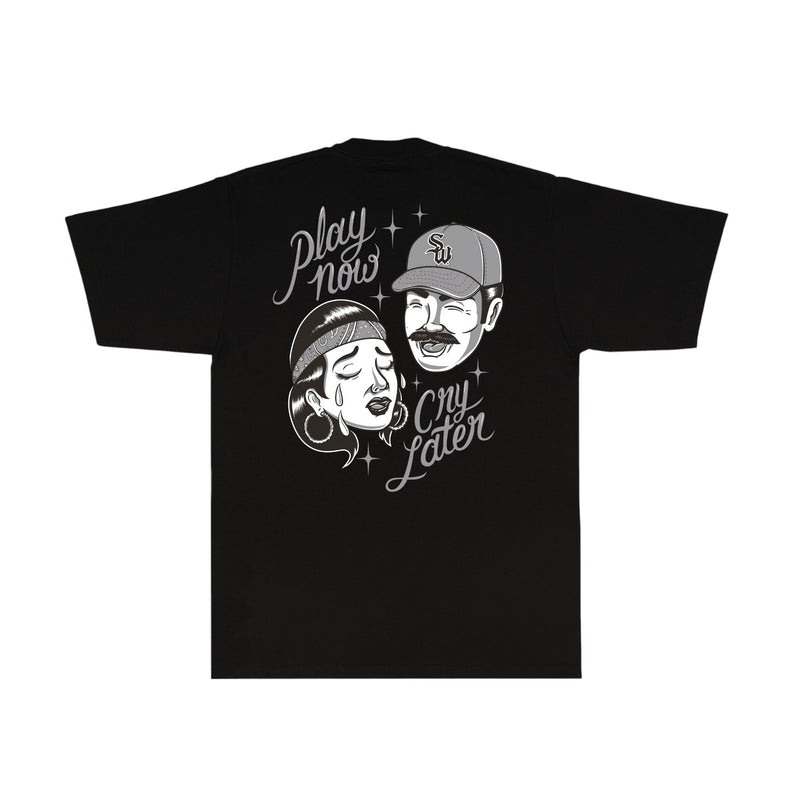 Load image into Gallery viewer, A black short-sleeve t-shirt with a white graphic print on the front, featuring a retro-style illustration of a man and woman wearing caps and bandanas, with the text 'Play now Cry later' and small star accents.
