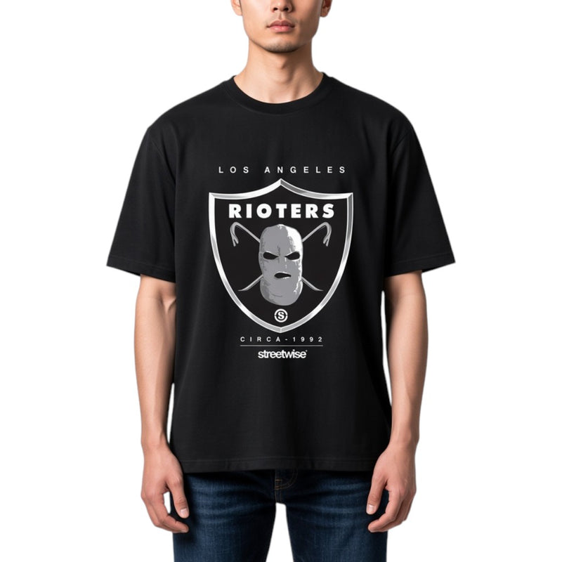 Load image into Gallery viewer, A man wearing a black Los Angeles Rioters t-shirt with a silver and white shield graphic on the front, paired with blue jeans, against a plain white background.
