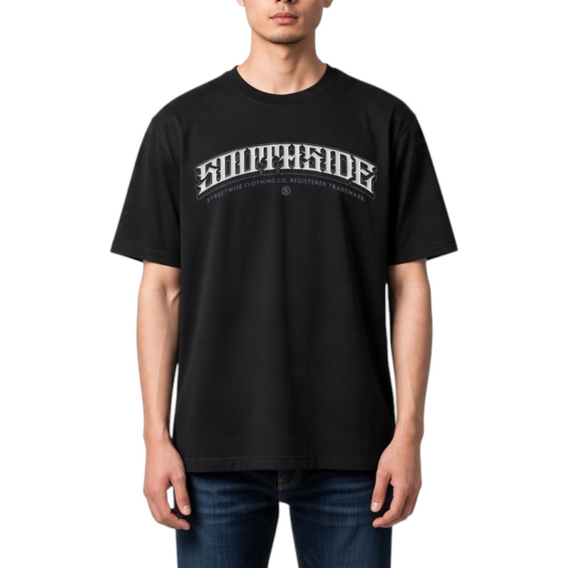 Load image into Gallery viewer, A man wearing a black short-sleeve t-shirt with a white arched 'SOUTHSIDE' graphic and smaller text underneath, paired with blue jeans, against a plain white background.
