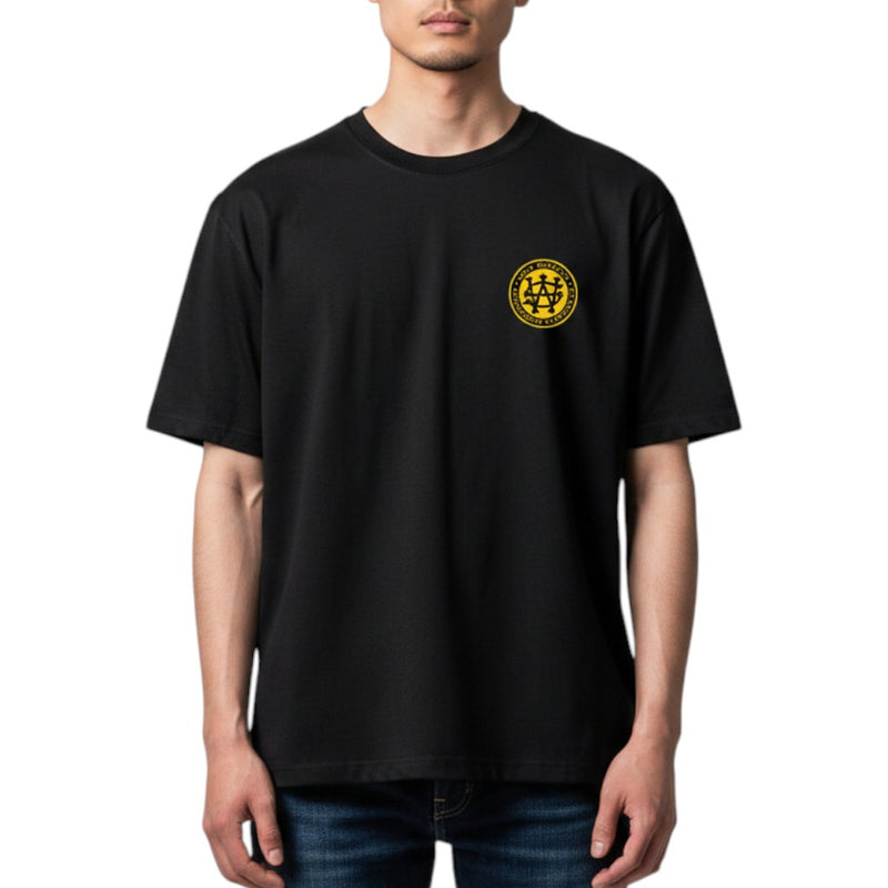 Load image into Gallery viewer, Person wearing a black t-shirt with a yellow logo on a white background
