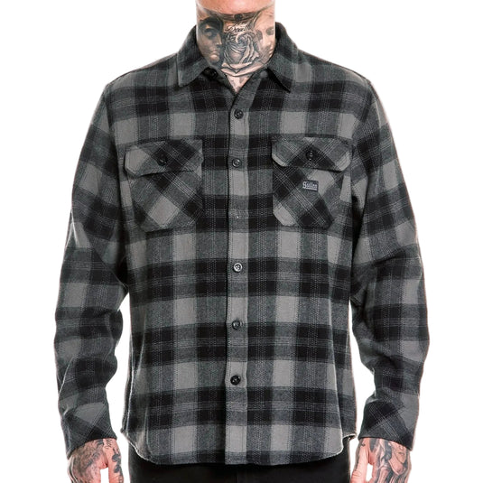 Person wearing a black and gray plaid shirt on a white background