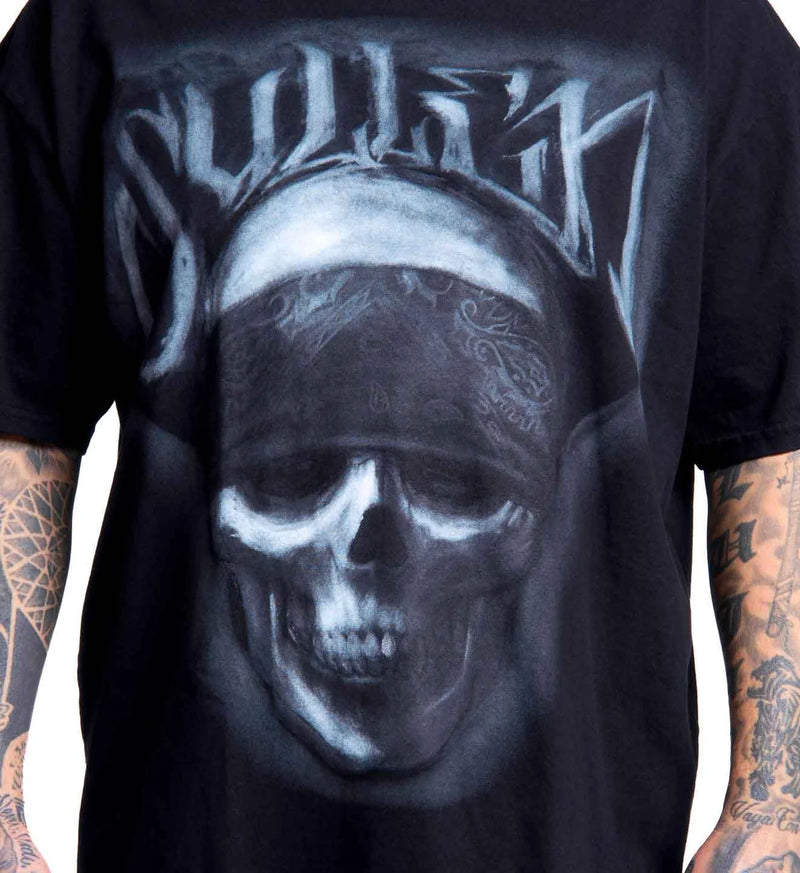 Load image into Gallery viewer, A close-up of a black graphic t-shirt featuring a large skull wearing a bandana, with stylized text above it. The shirt is shown on a model with tattooed arms against a plain white background.

