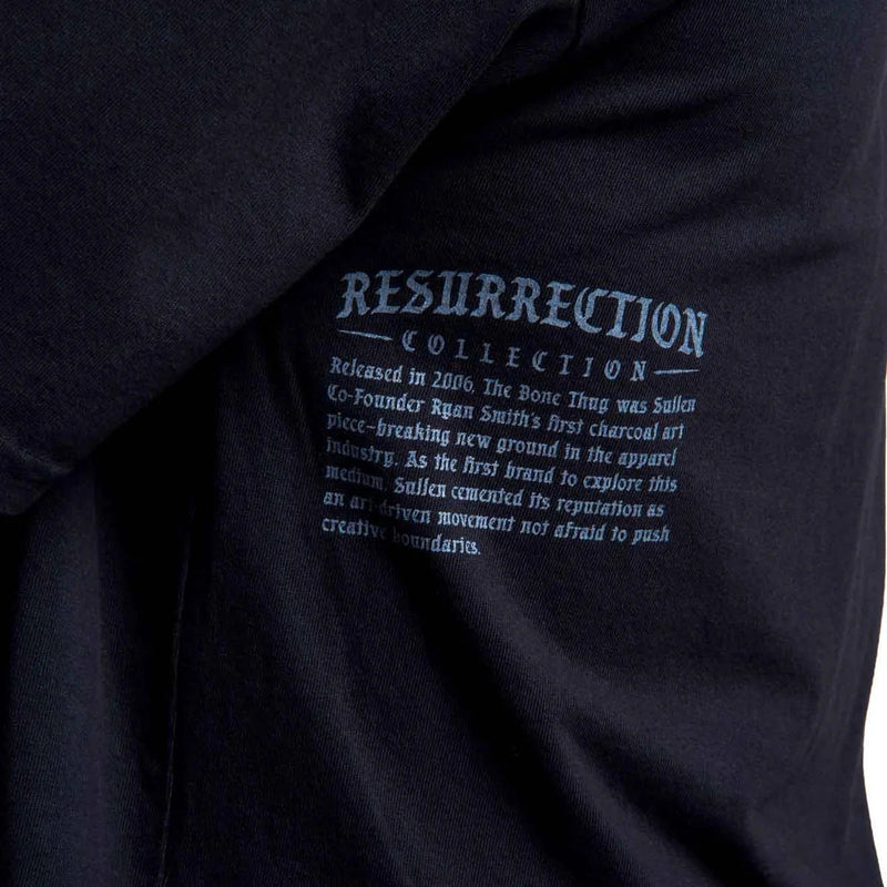 Load image into Gallery viewer, Close-up of a black T-shirt with light blue text reading 'RESURRECTION COLLECTION' and smaller descriptive text below, showing part of the garment fabric and print.
