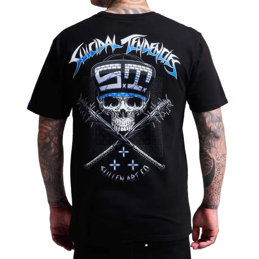 A man wearing a black t-shirt, viewed from the back. The shirt features a large graphic print of a skull wearing a blue and white striped hard hat, with crossed chains and the text 'Suicidal Tendencies' and 'SULLEN ART CO' in blue and white.