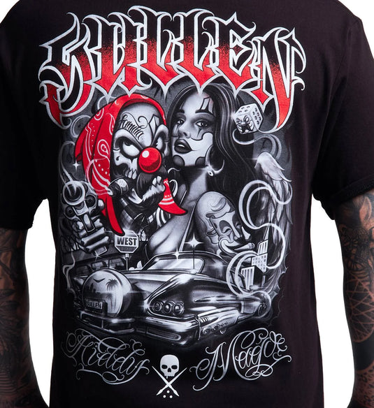A close-up of a black graphic t-shirt featuring a detailed design with the word 'Satan' in stylized white and red lettering, a red clown mask, a woman's face, a car, and gothic script text.