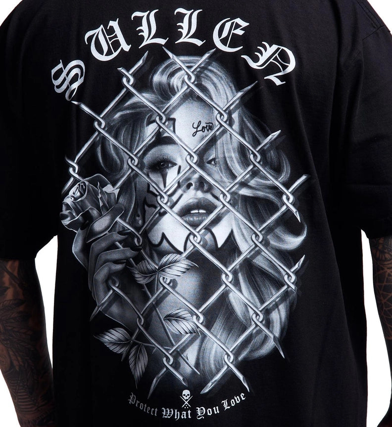 Load image into Gallery viewer, A close-up of a black graphic t-shirt featuring a detailed grayscale illustration of a woman's face behind a chain-link fence, with the word 'SULLEN' in white gothic lettering at the top.
