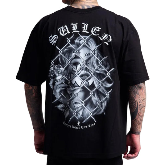 A man wearing a black t-shirt, viewed from the back. The shirt features a large graphic print of a skull and a woman behind a chain-link fence, with the word 'SULLEN' in a gothic font above and 'Protect What You Love!' below.