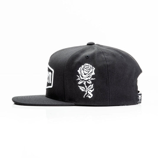 Sullen Black cap with an embroidered white rose design on a white background