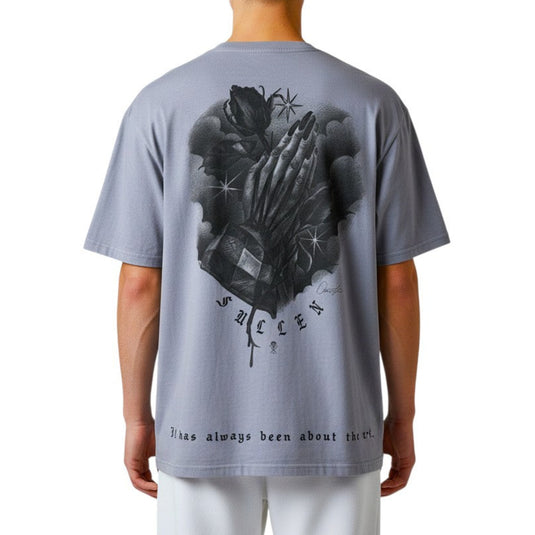 Person wearing a light blue t-shirt with a graphic design on a white background