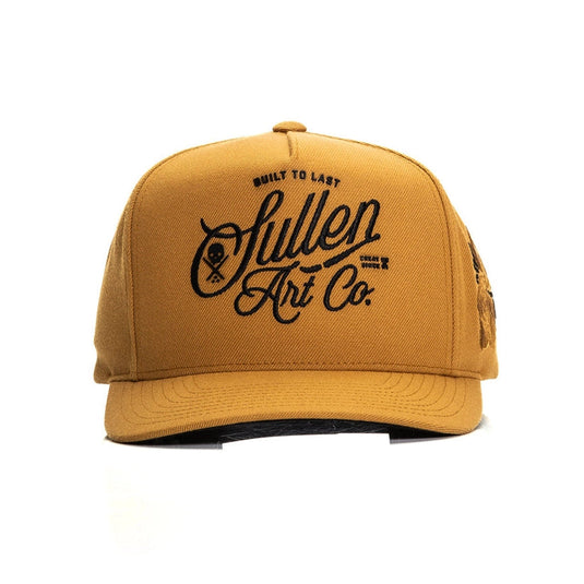 Camel colored cap with black embroidered design on the front panel and a camel embroidered rose patch on the left side of the hat on a white background