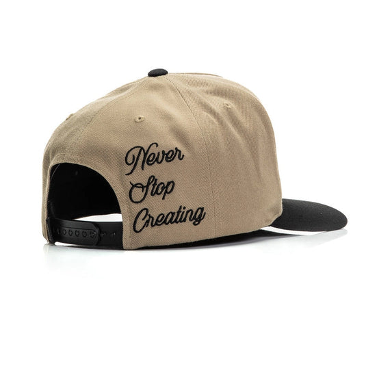 Beige cap with 'Never Stop Creating' text on a white background