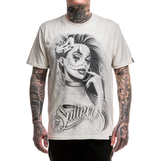 A man wearing a light beige graphic t-shirt with a black and white illustration of a woman's face and the word 'Sullen' printed on the front, set against a plain white background.