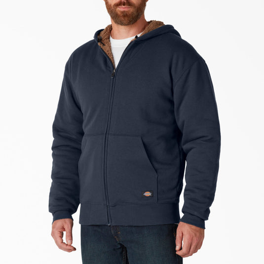 Man wearing a navy blue hoodie with brown lining on a white background