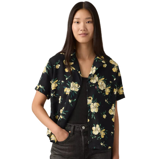 Woman wearing a black floral shirt with a Levi's red tab label on the side of the left chest pocket.