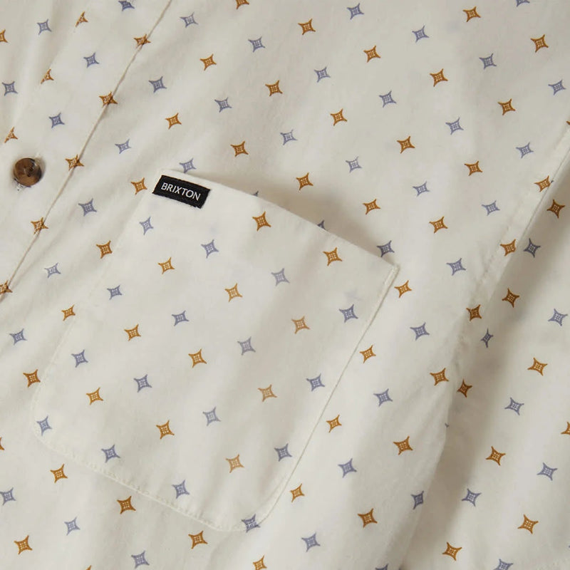 Load image into Gallery viewer, Multi-color diamond pattern print on button down shirt with a close-up of the left chest pocket featuring a small woven "Brixton" label.
