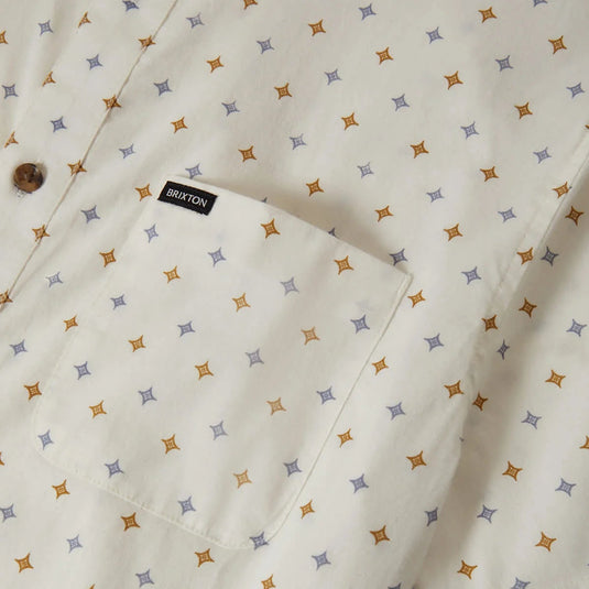 Multi-color diamond pattern print on button down shirt with a close-up of the left chest pocket featuring a small woven "Brixton" label.